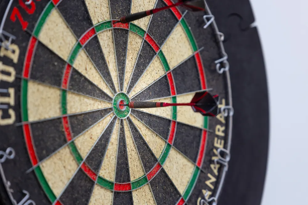 Pijlen in de roos van een dartsbord